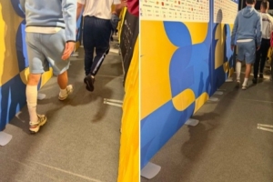 赖斯赛后跛行通过混合采访区，左小腿缠有绷带